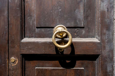 Antique door knocker on wooden door. Vintage, retro backgroundの写真素材