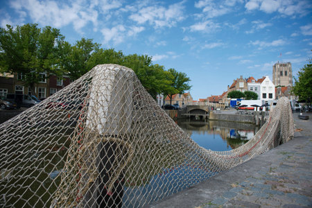 Goedereede, The Netherlands. Small harbor in the picturesque medieval town of Goedereede overlooking a beautiful old Gothic church tower that was used as a lighthouse at the time.の写真素材