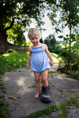 Little girl wears big grandfathers shoeの写真素材
