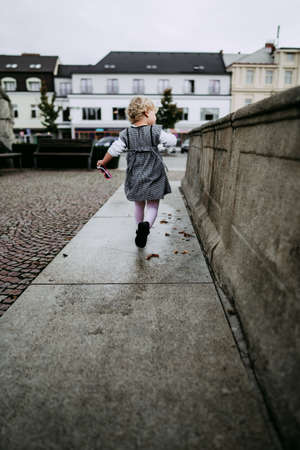 Little girl running in cityの写真素材
