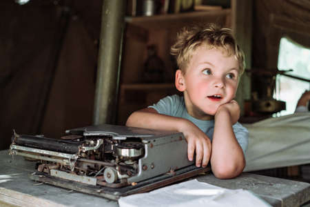 Little boy sitting in front of typewriterの写真素材