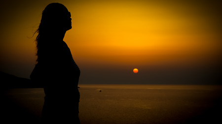 young woman sunset silhoutte on a coast during holiday, crete beachの写真素材