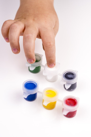 Child\'s finger is showing white colour of school tempera paintsの写真素材