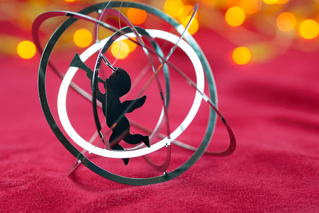 christmas angel with trumpet with yellow lights in the background in redの写真素材