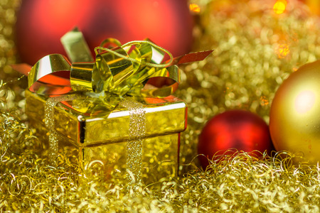 Christmas gift and balls on gloden backgroundの写真素材