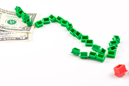 chart pattern made of miniatur green houses is falling, business conceptの写真素材