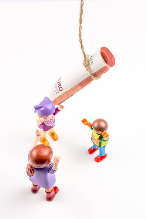 three little persons and one euro banknote on a string, business concept