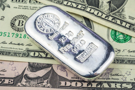 silver brick laying on dollar banknotes