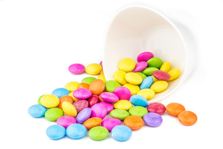 multicolored sweet choco lentils scattered on white backgroundの写真素材