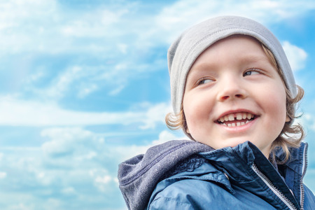 smiling boy with cloudy background during sunny spring dayの写真素材