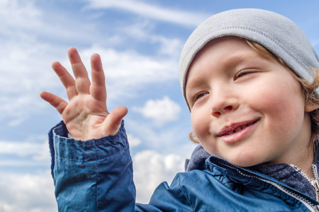 laughing boy with cloudy background during a sunny spring dayの写真素材