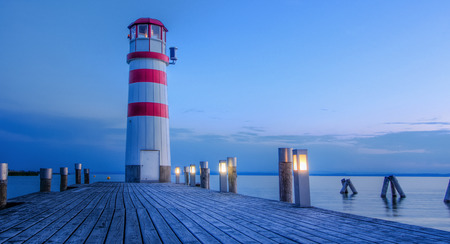 red striped lighthouse in one summer evening somewhere in Europeの写真素材
