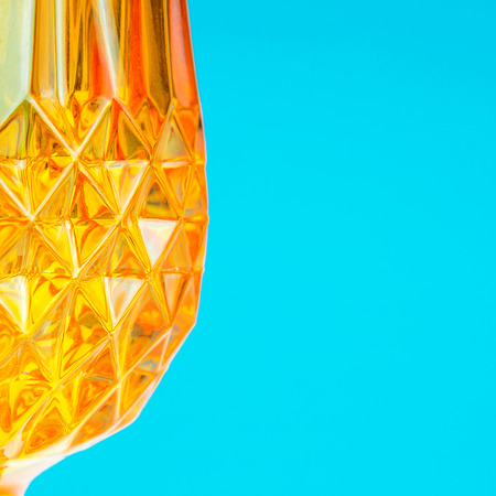 orange glass on blue background with one part defocusedの写真素材