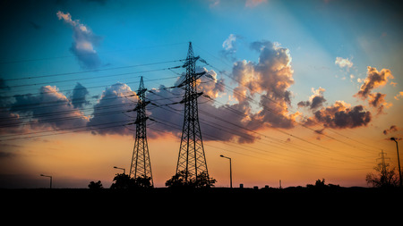 silhuettes of electricity pylons in the evening, high voltage mastsの写真素材