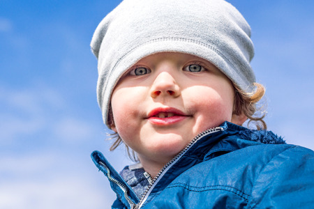 young handsome boy enjoying a stay on fresh air with blue cloudy sky in the backgroundの写真素材