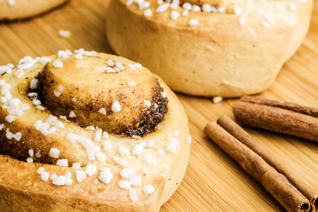 cinnamon spiral cakes on wooden background with cinnamonの写真素材