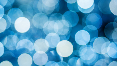 beautiful bokeh made of cold white blurred lights on blue backgroundの写真素材