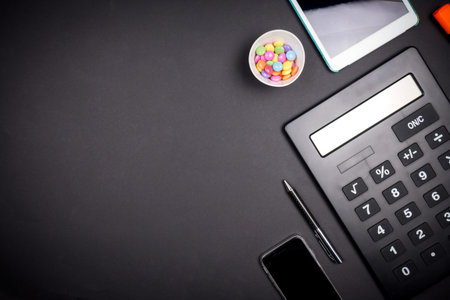 view of office space with business tools from above on black background with vignetting and copy...