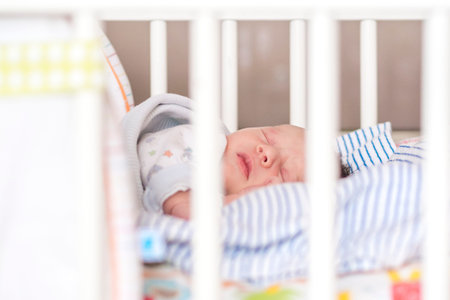 newborn child sleeping in white wooden crib