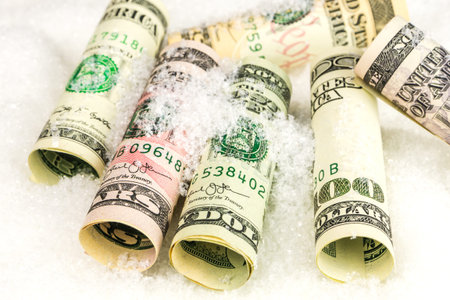 american dollar banknote rolls in all denominations covered with snow
