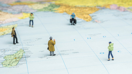 closeup of miniature figurine of young traveler standing on big map next to the Indian ocean regionの写真素材