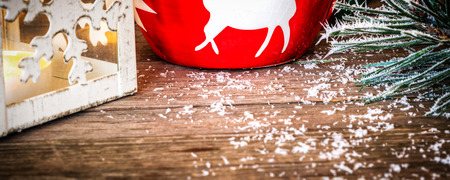 winter time in Europe, closeup of wooden desk with fir branch covered with snow and lit candlestickの写真素材
