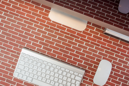 top view of an office place with modern technology on red brick backgroundの写真素材