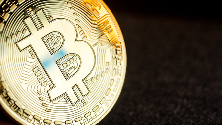 closeup of golden bitcoin coin on black backgroundの写真素材