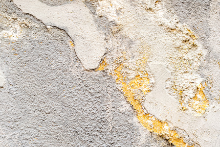 closeup of dirty white concrete wall with facade detail and many irregularitiesの写真素材