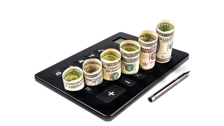 dollar banknotes with different values forming rising steps on big black calculator on white backgroundの写真素材