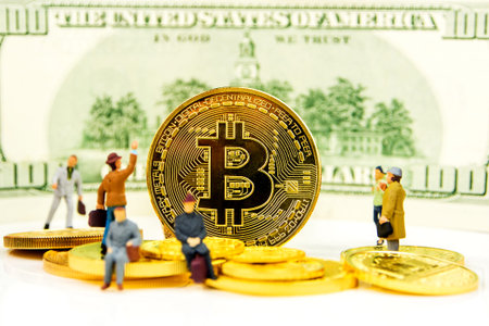 Close-up golden Bitcoin coin with banknote, golden coins and miniature figurines standing around.