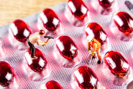 miniature figurines working hard together in order to make medicine, pill best possibleの写真素材