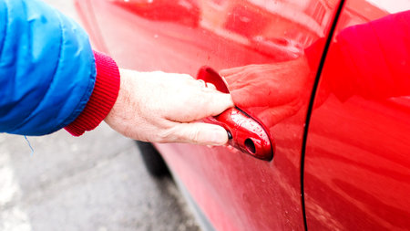 married man is opening front door of his red dirty car without car key