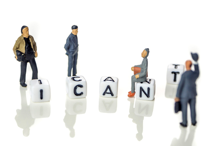 Removing white cube with letter "t" from the word "i can't" creating new word "I can", personal development and career growth or change yourself concept, white background with miniature figurines watching at itの写真素材