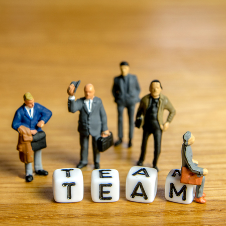 little miniature figurines with little dices forming specific word as a part of team meeting collection pictures dedicated to one part of its time table on wooden backgroundの写真素材