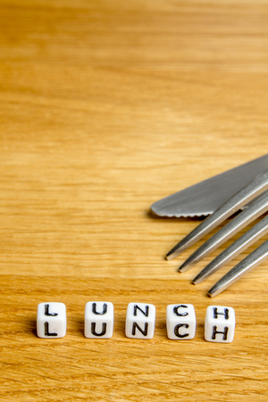 little miniature figurines with little dices forming specific word as a part of team meeting collection pictures dedicated to one part of its time table on wooden backgroundの写真素材