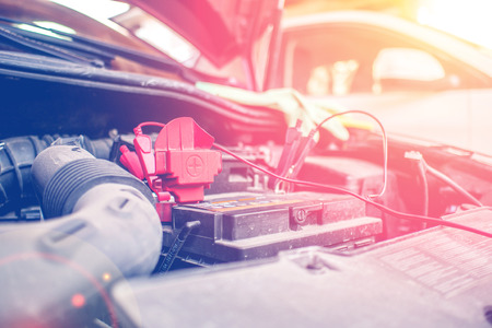 battery clamps connected to the empty car accumulator while charging it fully with battery chargerの写真素材