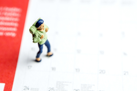 closeup of miniature figurines standing on diary calendar planning theirs office routine as a part of his team business lifeの写真素材