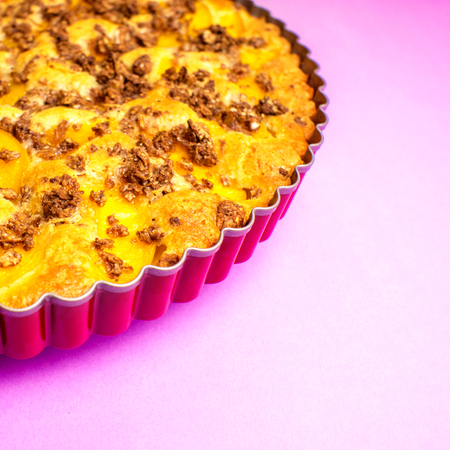 closeup of apple pie with oat flakes in violet fom on violet backgroundの写真素材