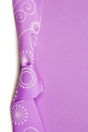 birthday gift card with violet bow and ribbon in the middle isolated and violet and white background with plenty copy space for the textの写真素材