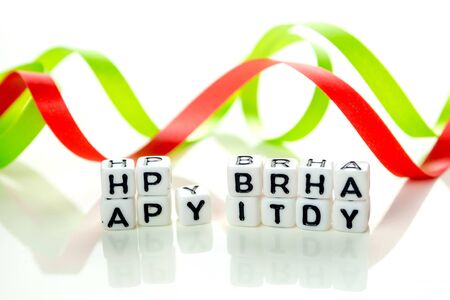 happy birthday special unconventional card made of white cubes with black letters and green birthday decorations on white backgroundの写真素材