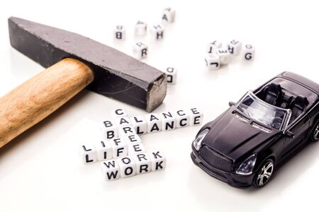 little white dices with black letters forming a crossword with the theme work life balance as equilibrium of professional and personal family life with tools on white backgroundの写真素材