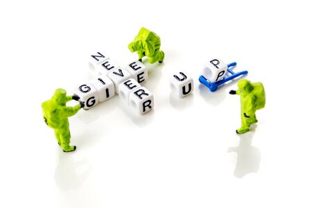 never give up quote formed of white dices with black letters and green little miniature figurines of special forces on white background, motivation and survive theme with a lot of copy spaceの写真素材
