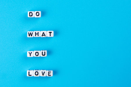 little white dices forming a text do what you love as positive lifestyle theme on blue backgroundの写真素材