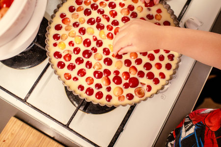 young boy is cooking and baking cherry pie with almond slices with his mamm