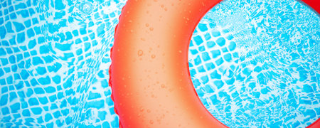 view of red inflatable swiming wheel in a swimming pool during a hot summer day