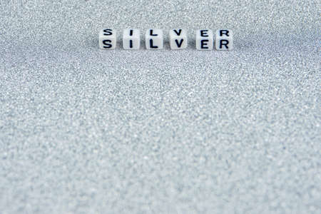 silver word formed by white dices with black letters  laying in upper part of silver backgroundの写真素材
