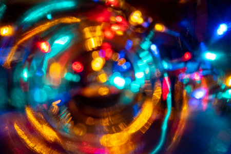 vibrant color blurred celebration dancing night lights in the city life may be used as party, birthday, christmas or night city life themed backgroundの写真素材