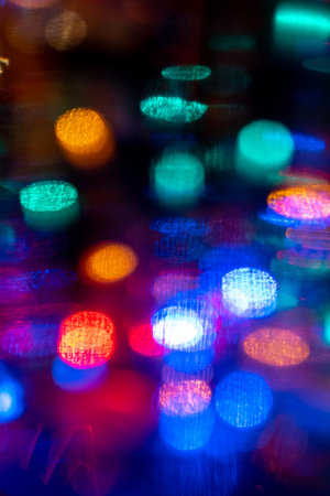 vibrant color blurred celebration dancing night lights in the city life may be used as party, birthday, christmas or night city life themed backgroundの写真素材