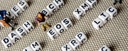 set of popular crypto coins forming rows made of white cubes with black capital letters and miniature businessmen figurines having a team meeting, bitcoin, altcoins, ethereum, ripple, lumen, eos, litecoin, omisego, moneroの写真素材